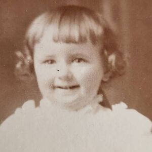 Antique cabinet photograph Caucasian toddler girl smiling  on chair black & whit